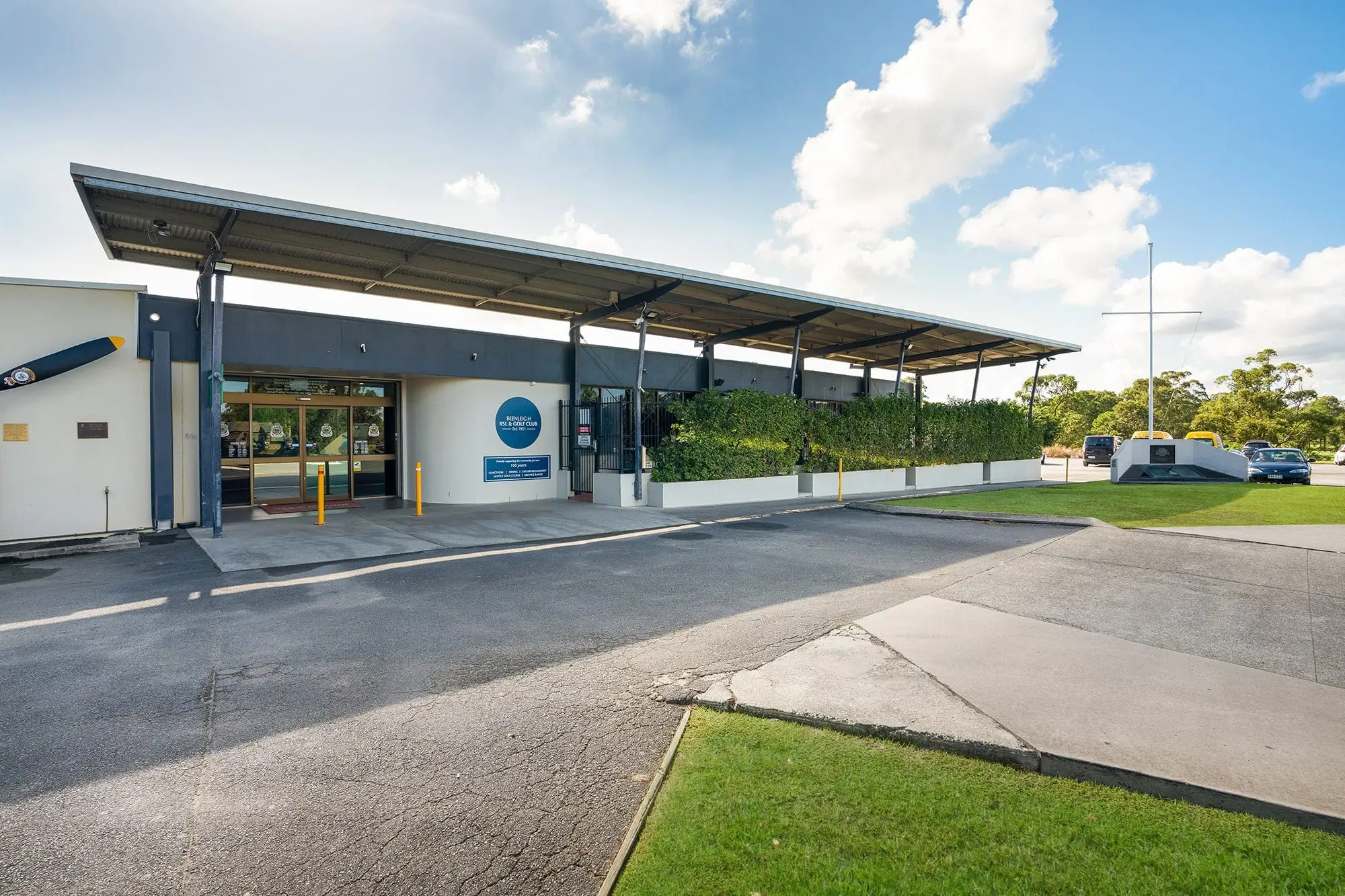 Clubhouse entrance with covered walkway under blue sky