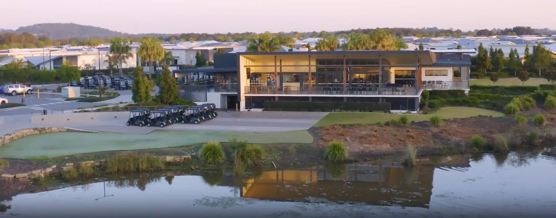 Modern clubhouse overlooking the lake and course at dusk