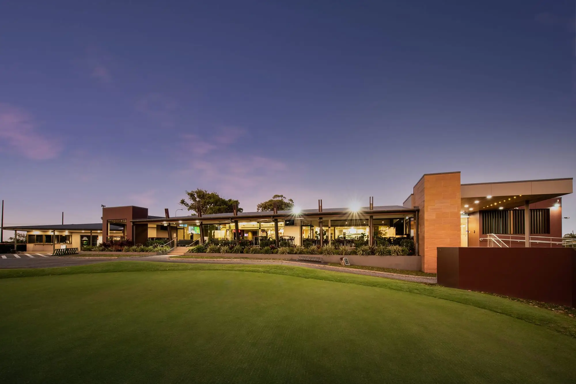 Modern clubhouse at dusk overlooking the course