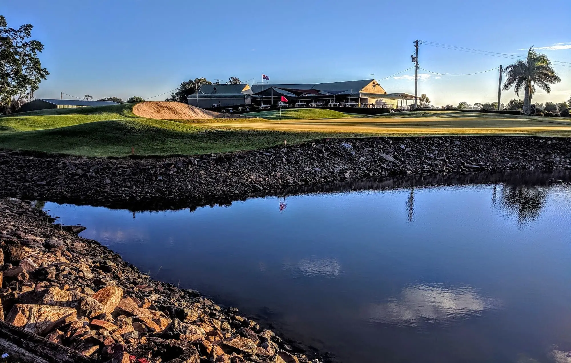Clubhouse across a still water hazard at sunset