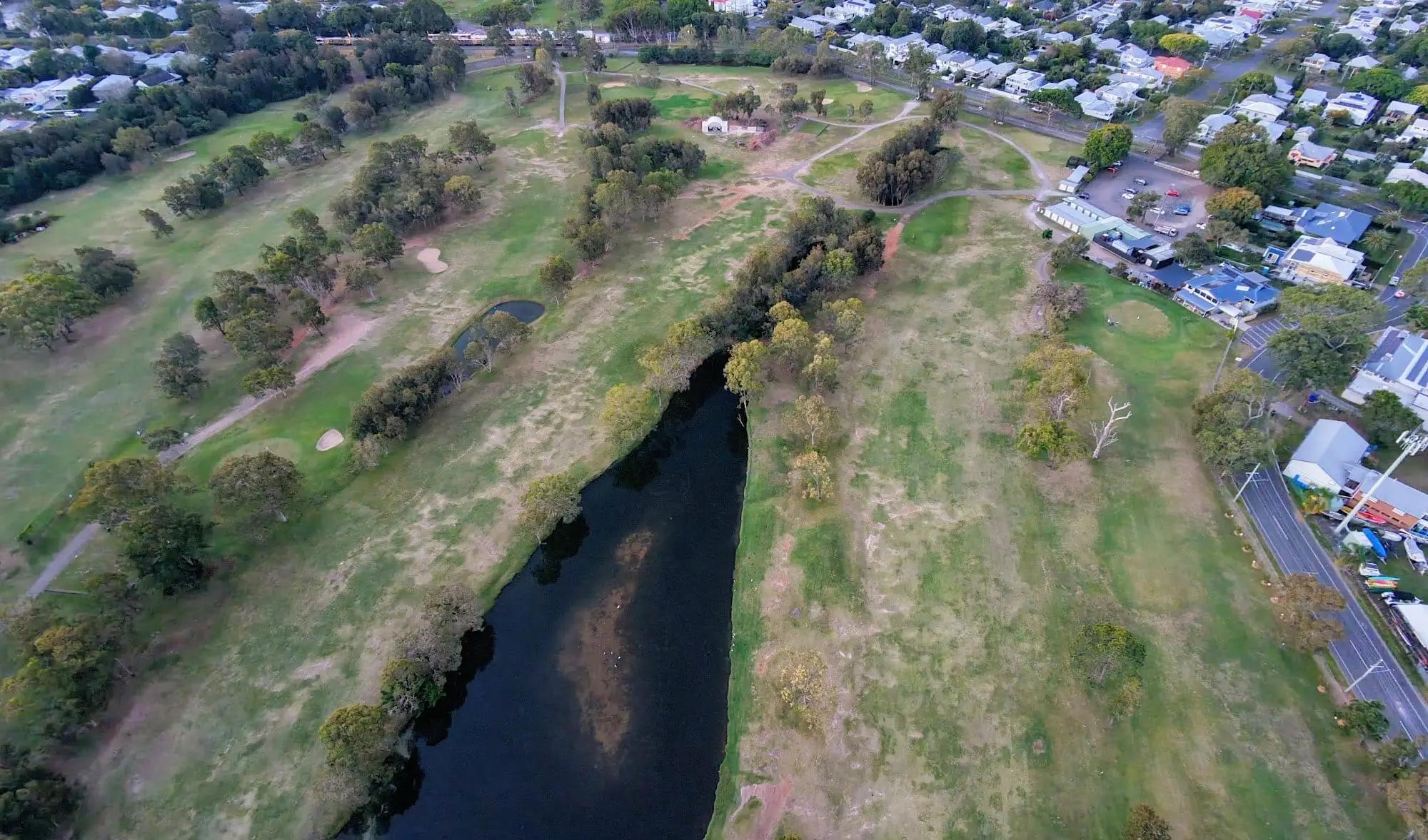 Aerial view of a creek winding beside a fairway