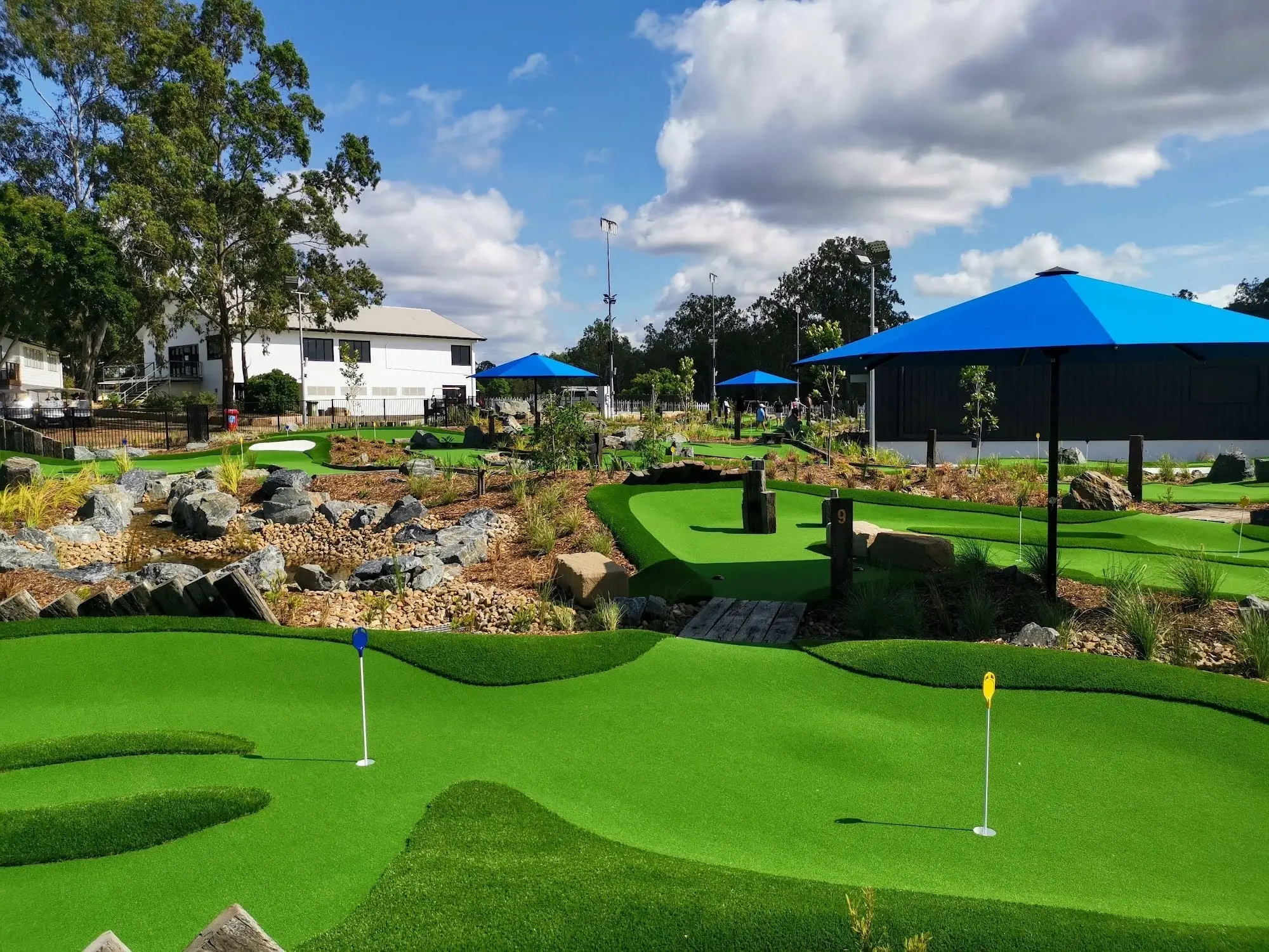 Putting course with flags, rock gardens and blue umbrellas