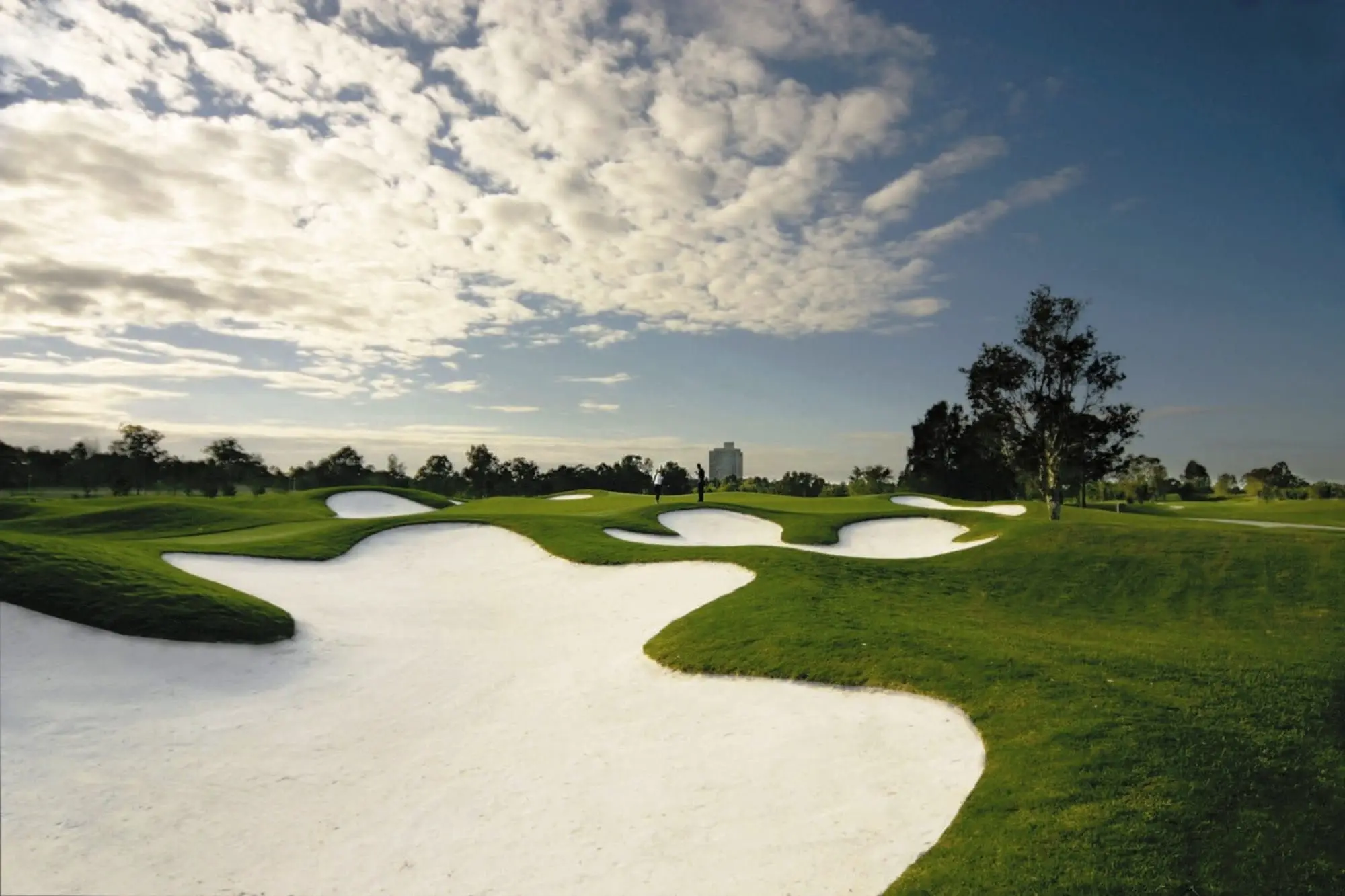 Sweeping bunkers on a fairway under dramatic sky
