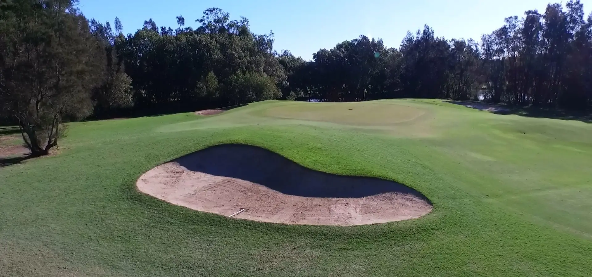 Large bunker guarding a green with trees behind