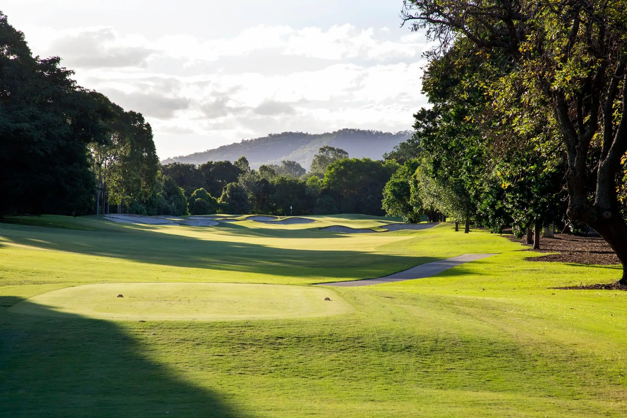 Fairway looking toward distant hills and tall trees