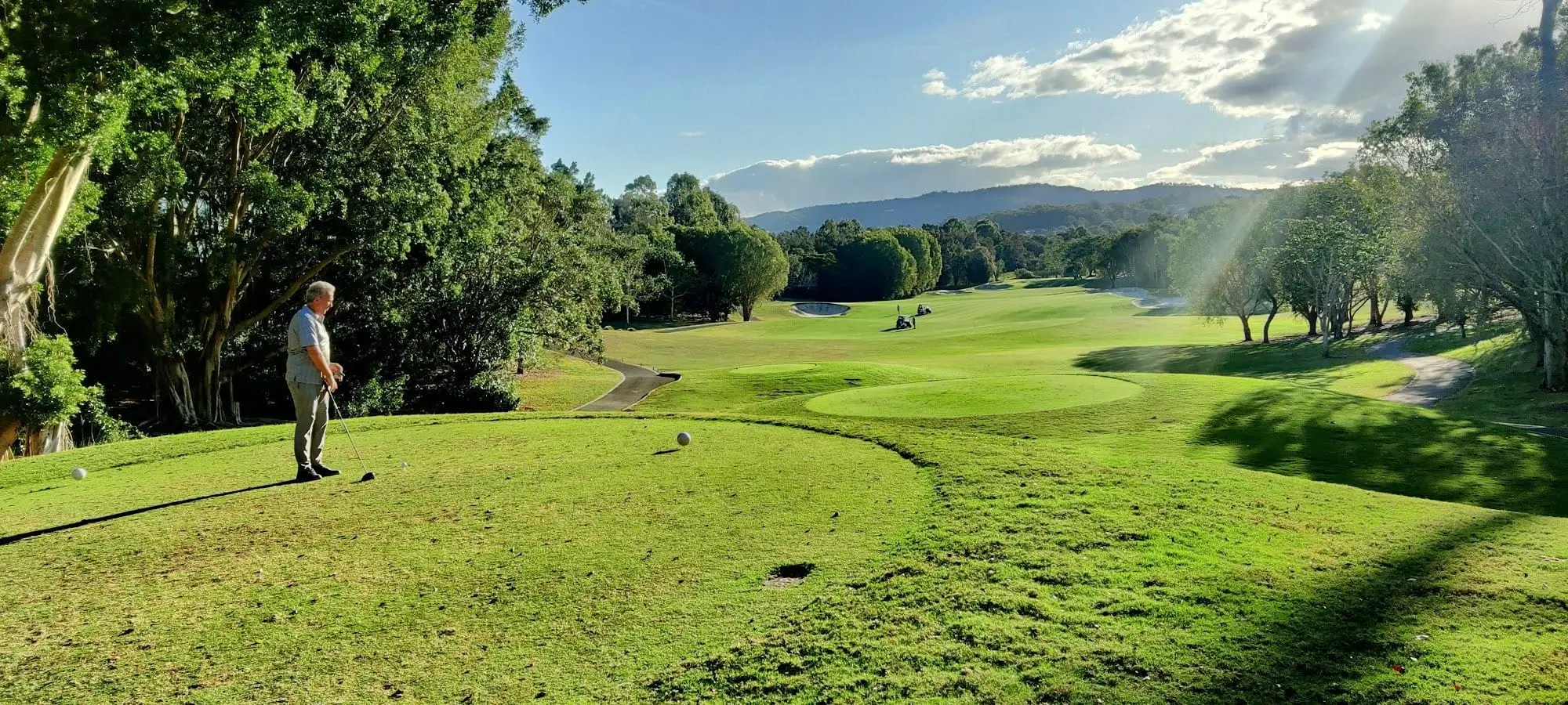 Elevated tee looking over fairway to distant mountains
