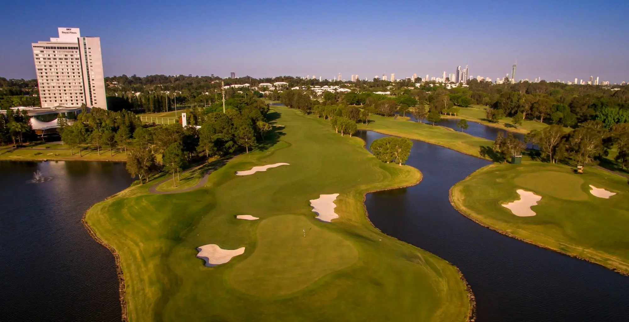 Aerial view of green and bunkers surrounded by water