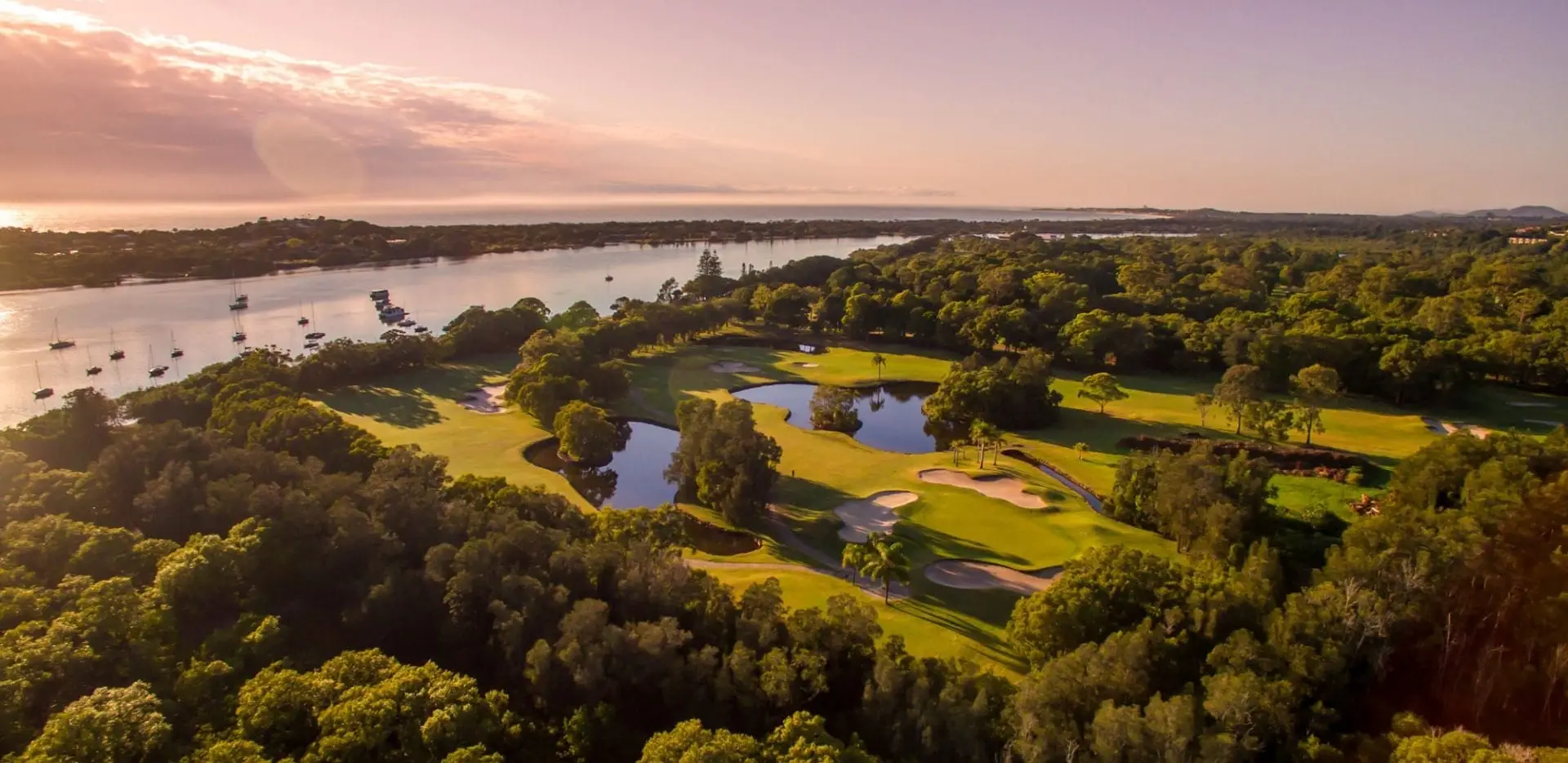 Aerial of course and ponds at sunrise beside the river