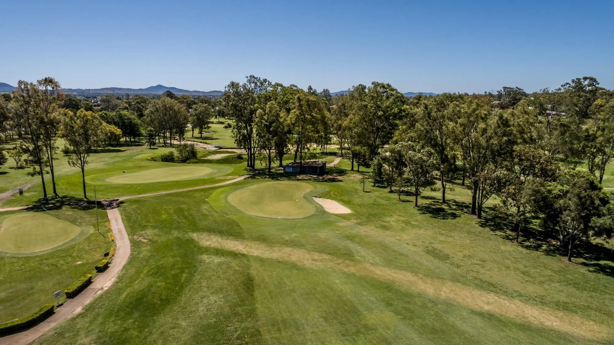 Elevated view across fairway and green with distant mountains