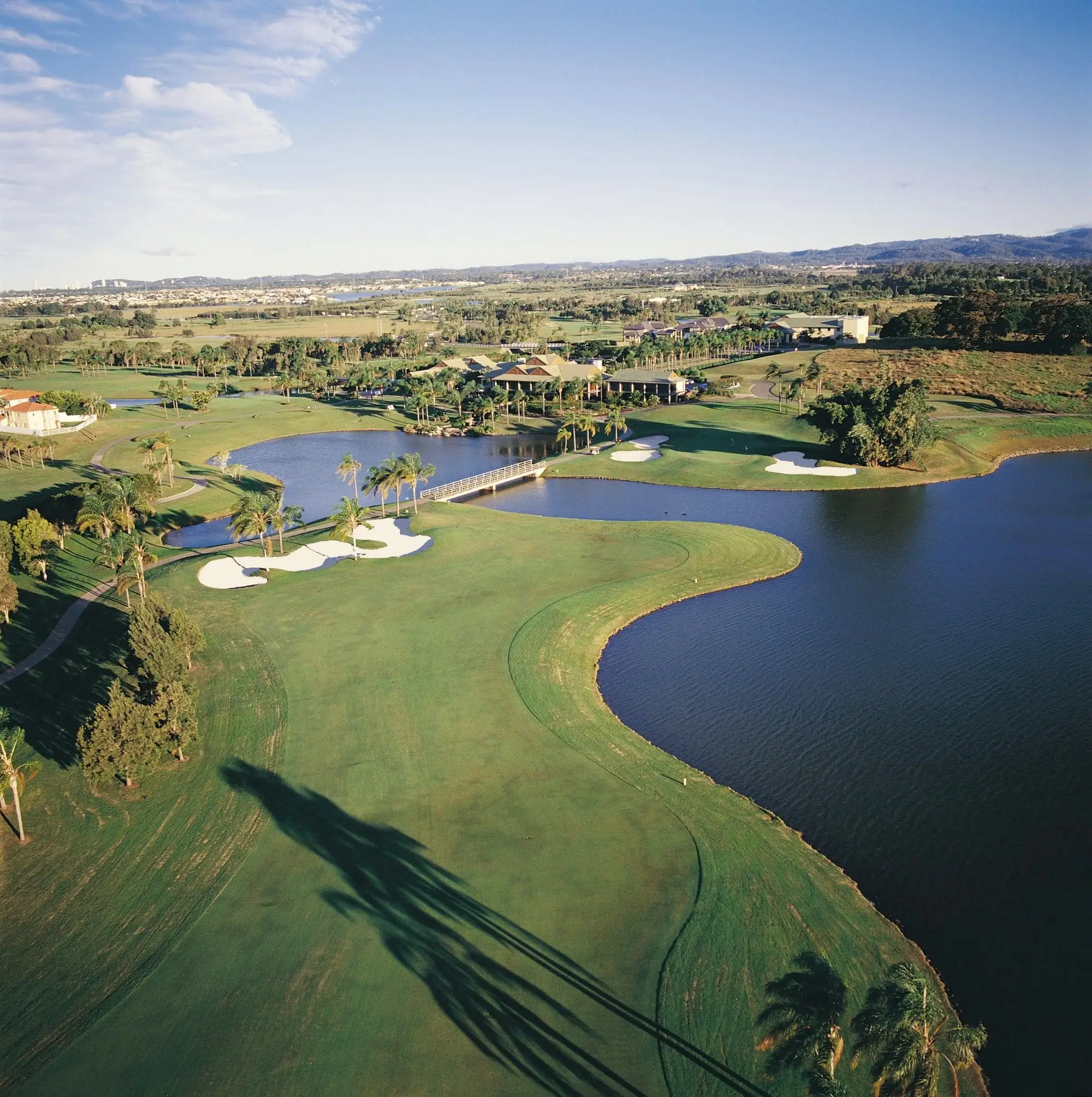 Aerial of a lake bordering a green with bunkers