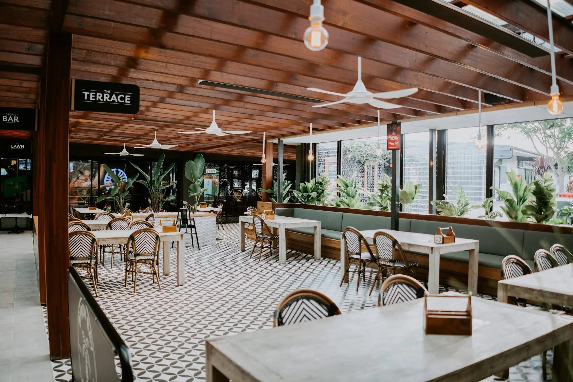Covered terrace dining area with tables looking out to the course
