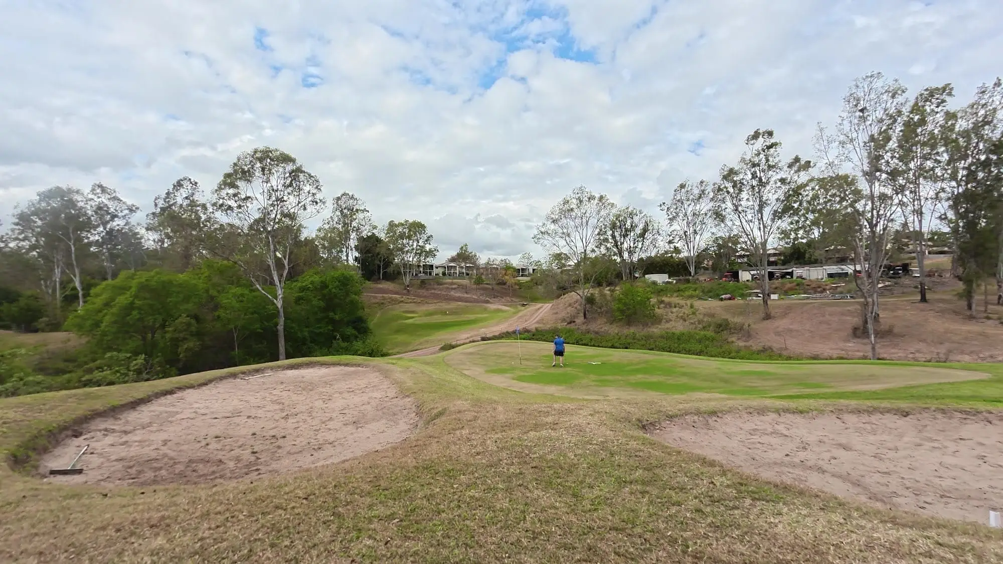 Sandy bunkers and dry fairway under a cloudy sky