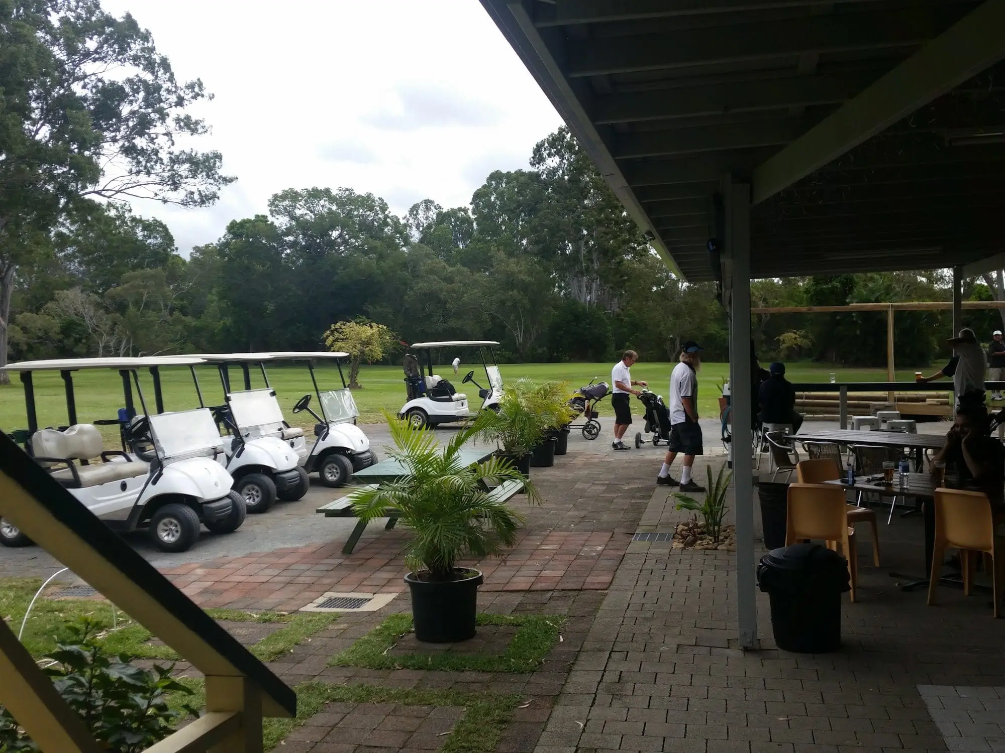 Buggies parked beside a covered patio overlooking the course