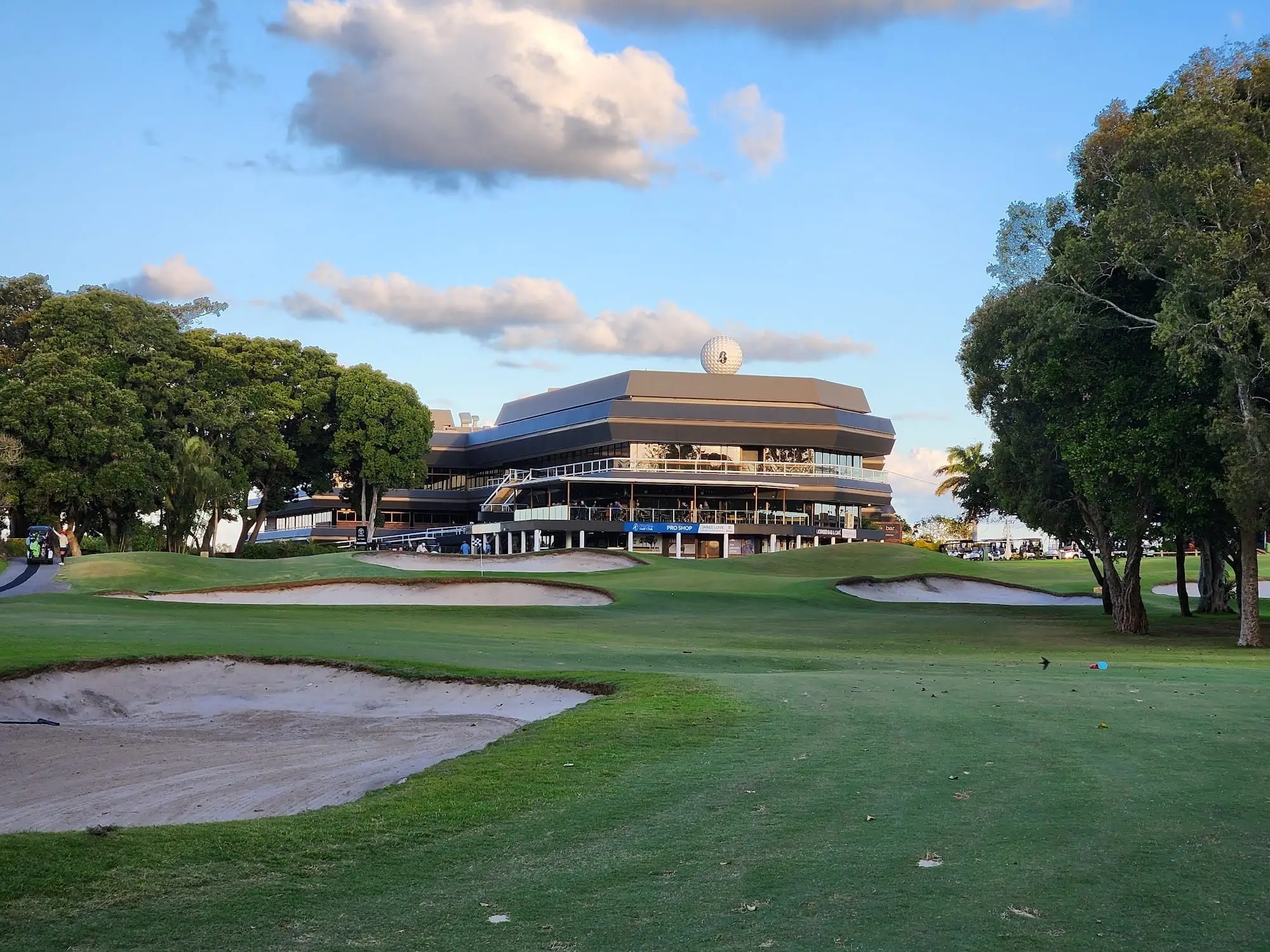 Clubhouse behind a bunker and fairway