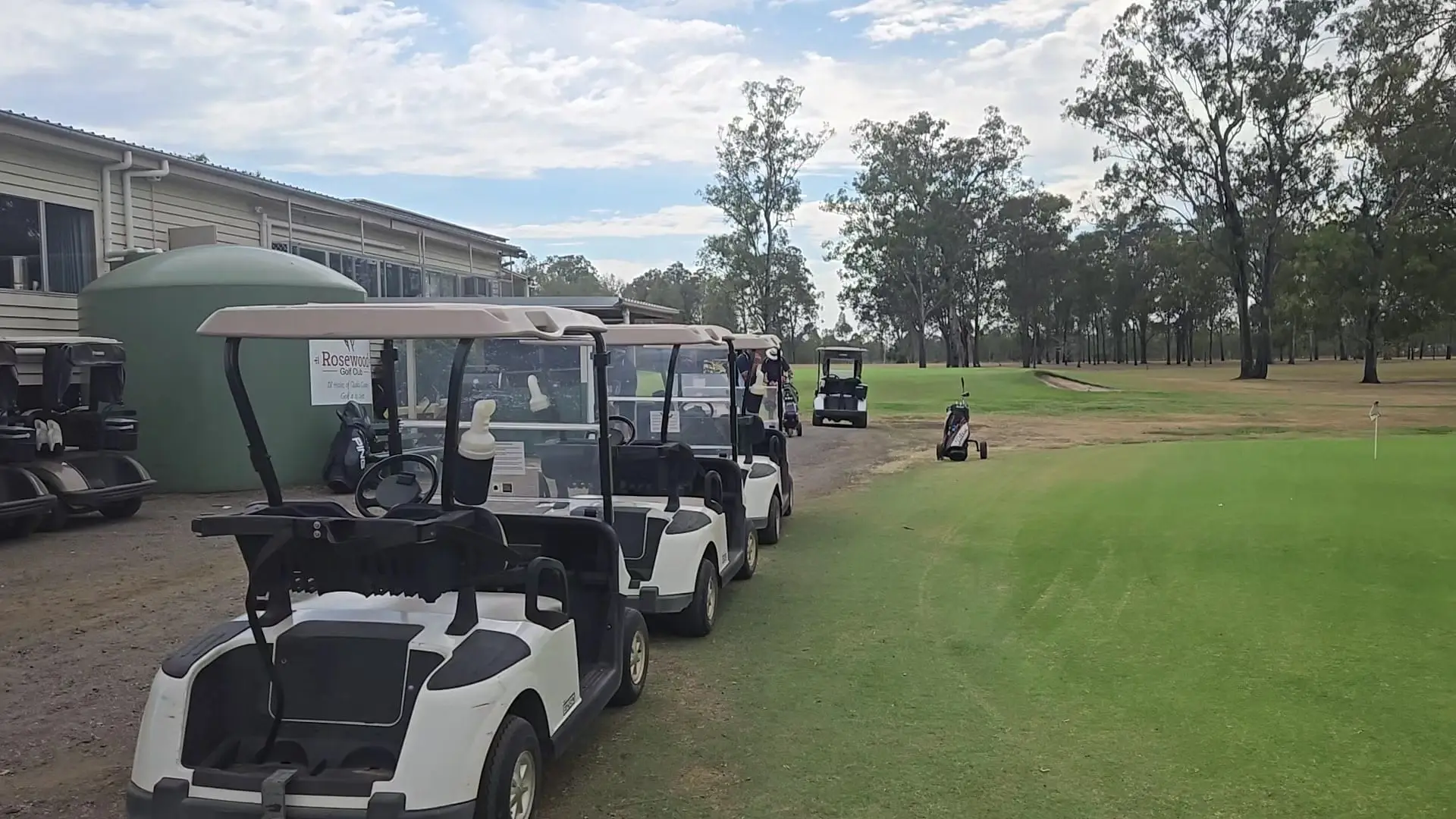 Fairway and carts beside the clubhouse at the start of the round