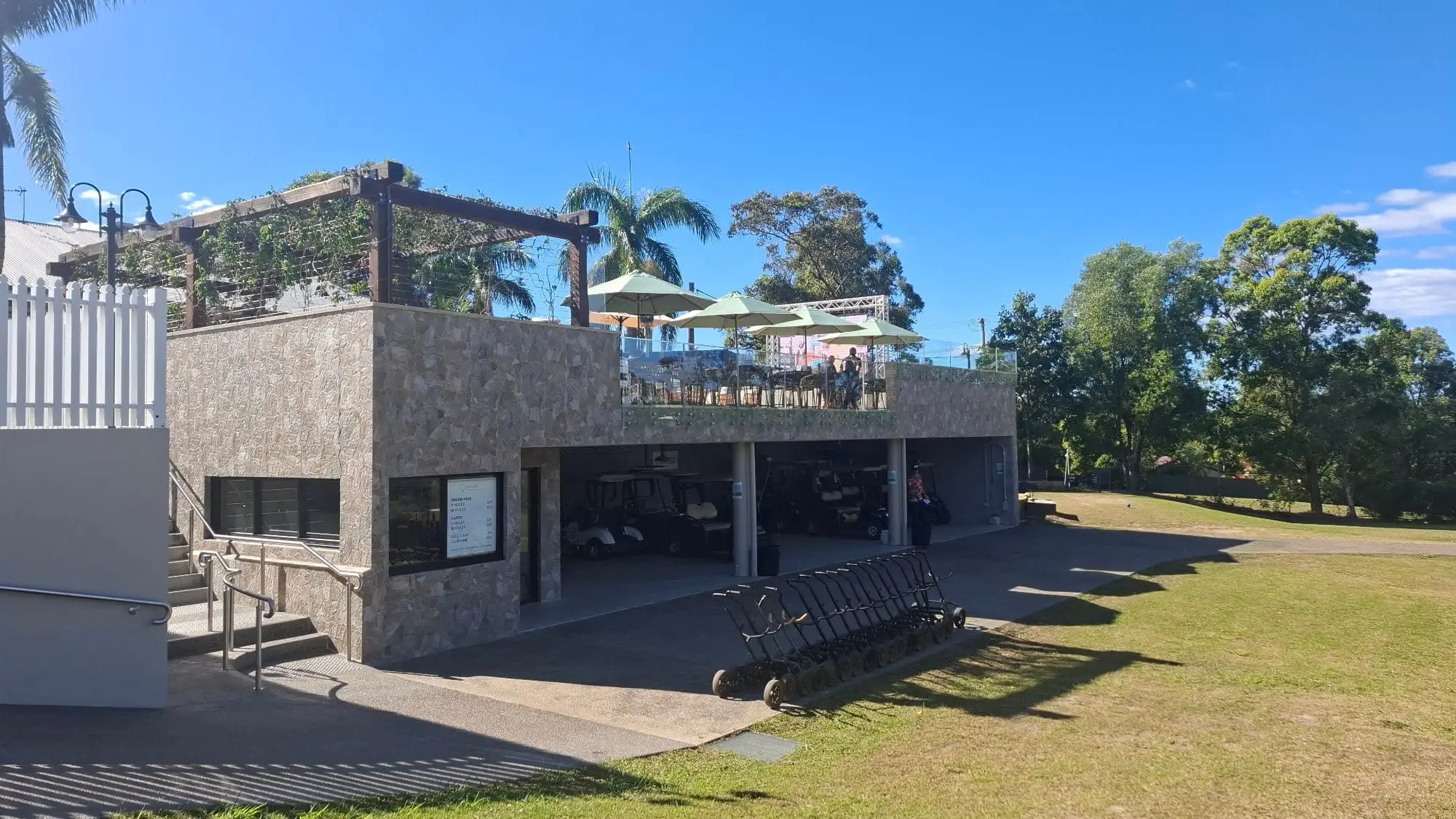 Clubhouse terrace with umbrellas above the course