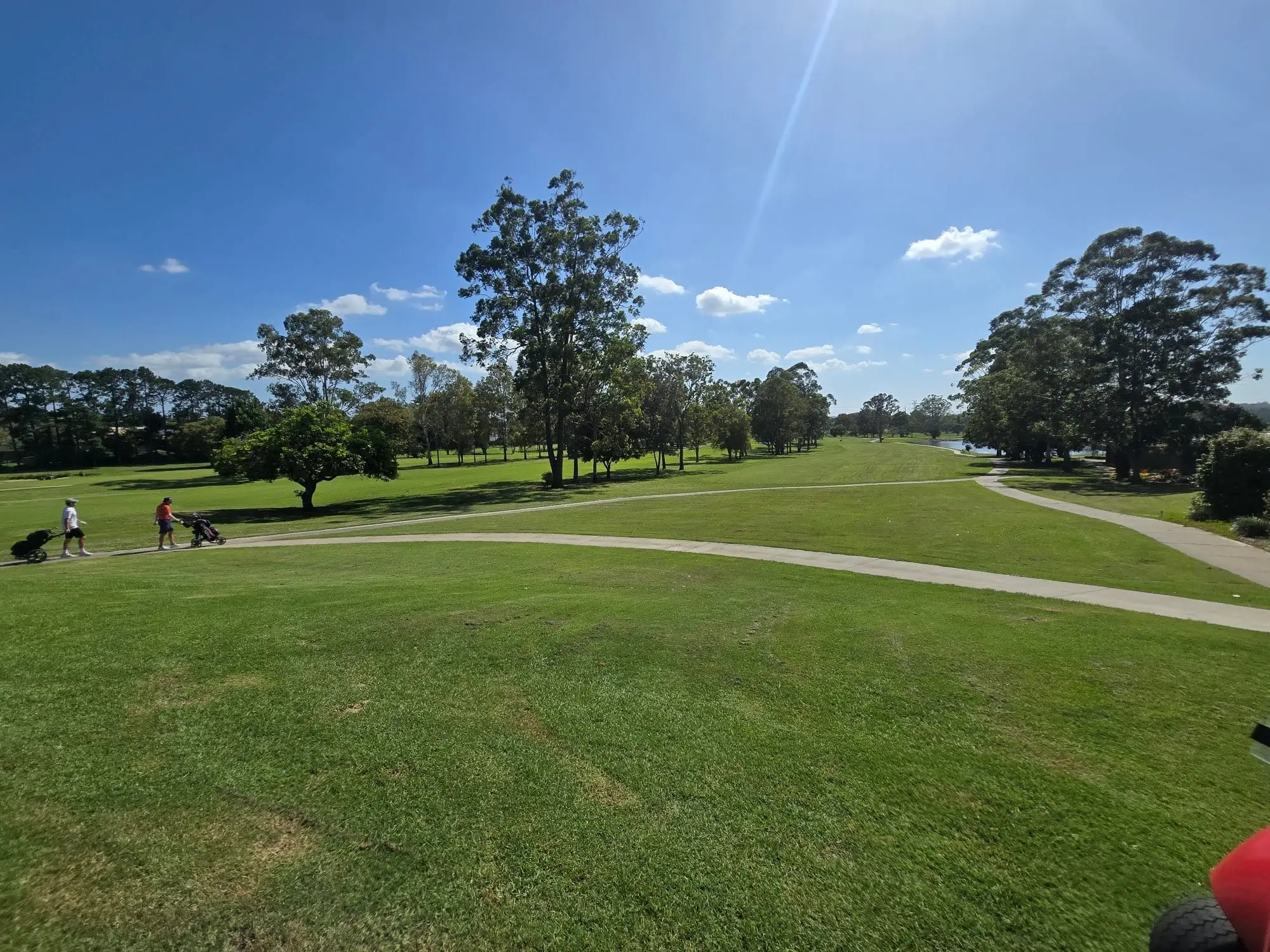 Fairway and cart path winding beneath blue skies