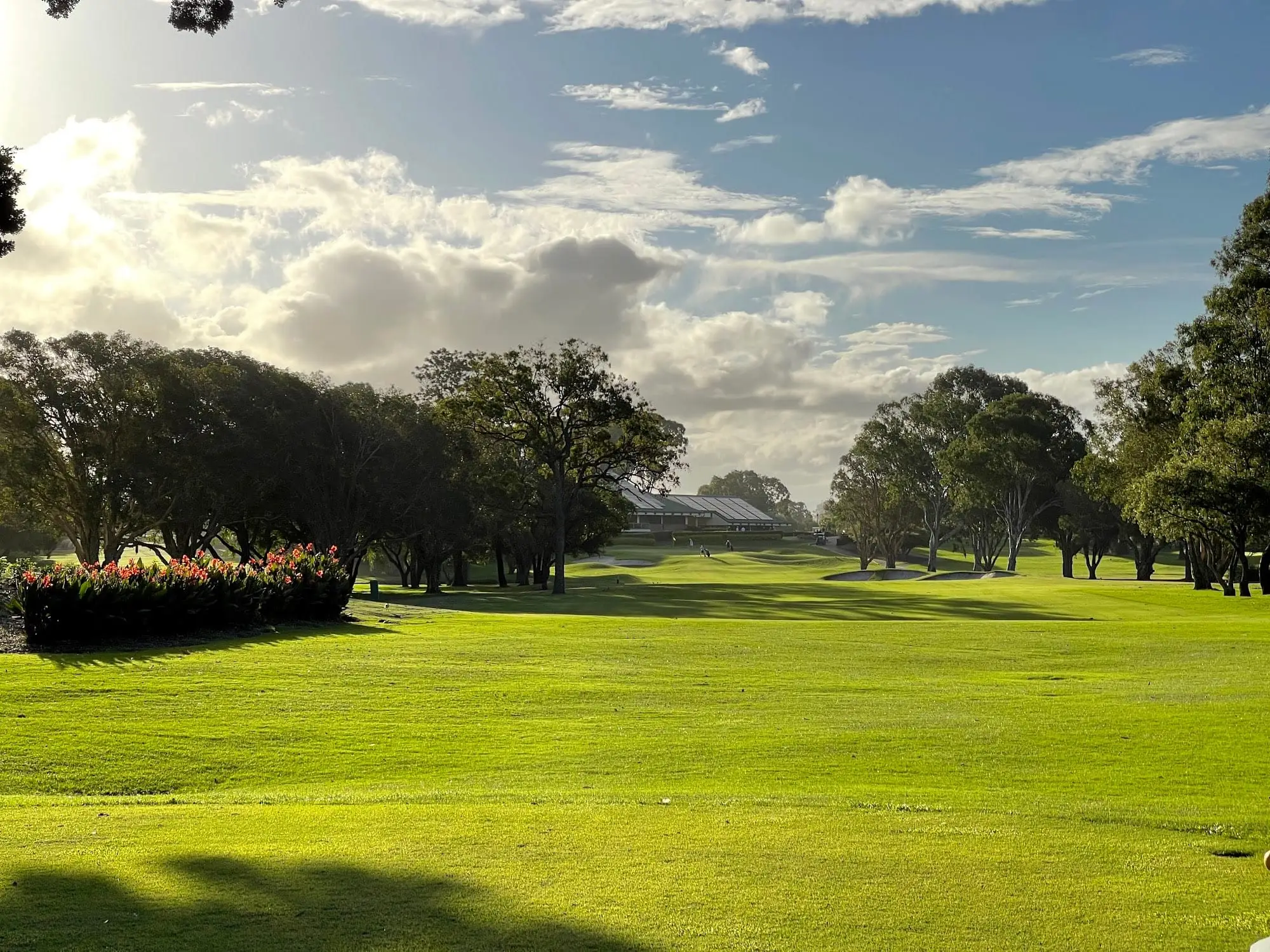 Wide fairway and putting green under a dramatic cloudy sky
