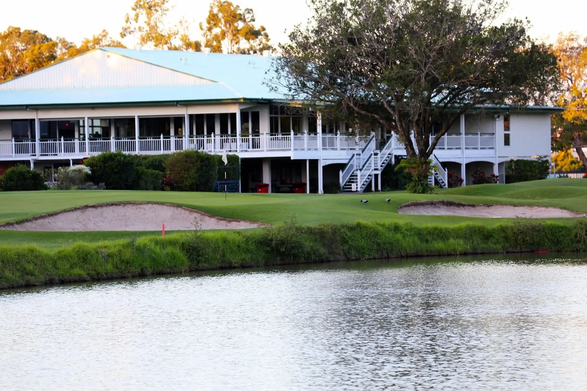 Clubhouse across a pond and bunkers