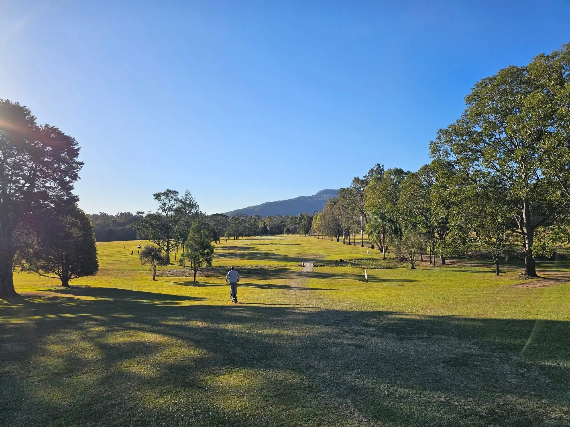 Fairway in late afternoon light with hills in distance