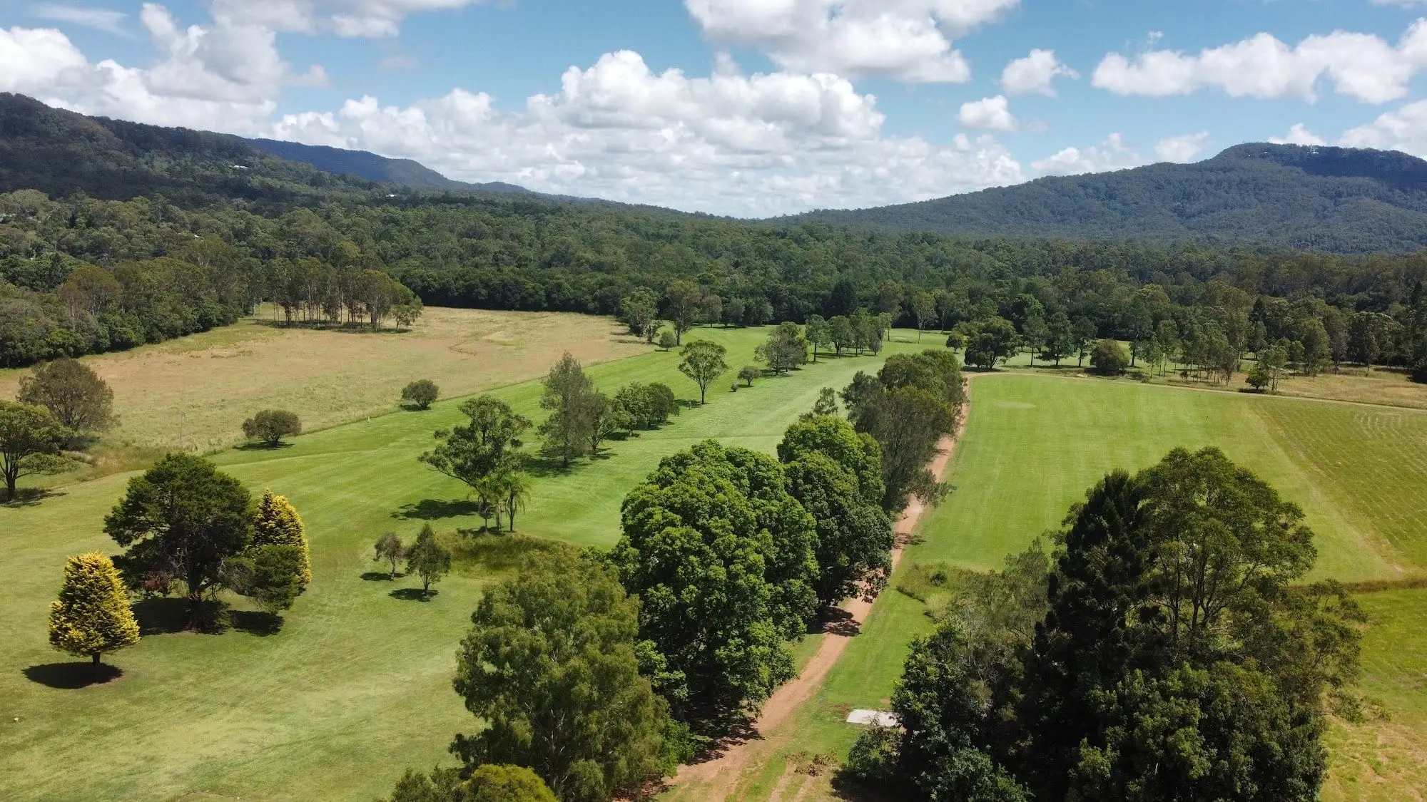 Aerial view of fairway lined with trees in a valley