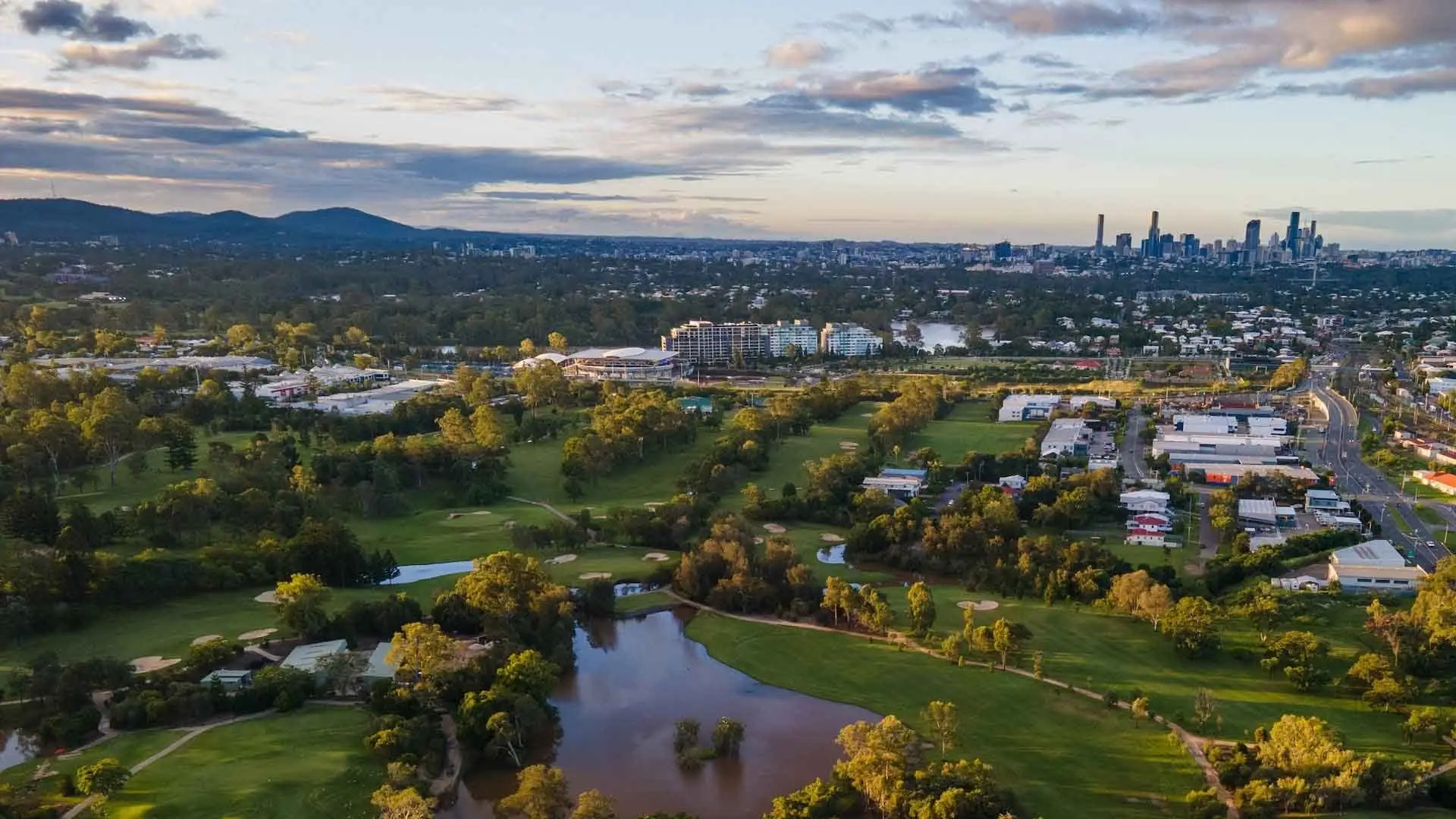 Aerial view of course, lake and city skyline in evening light