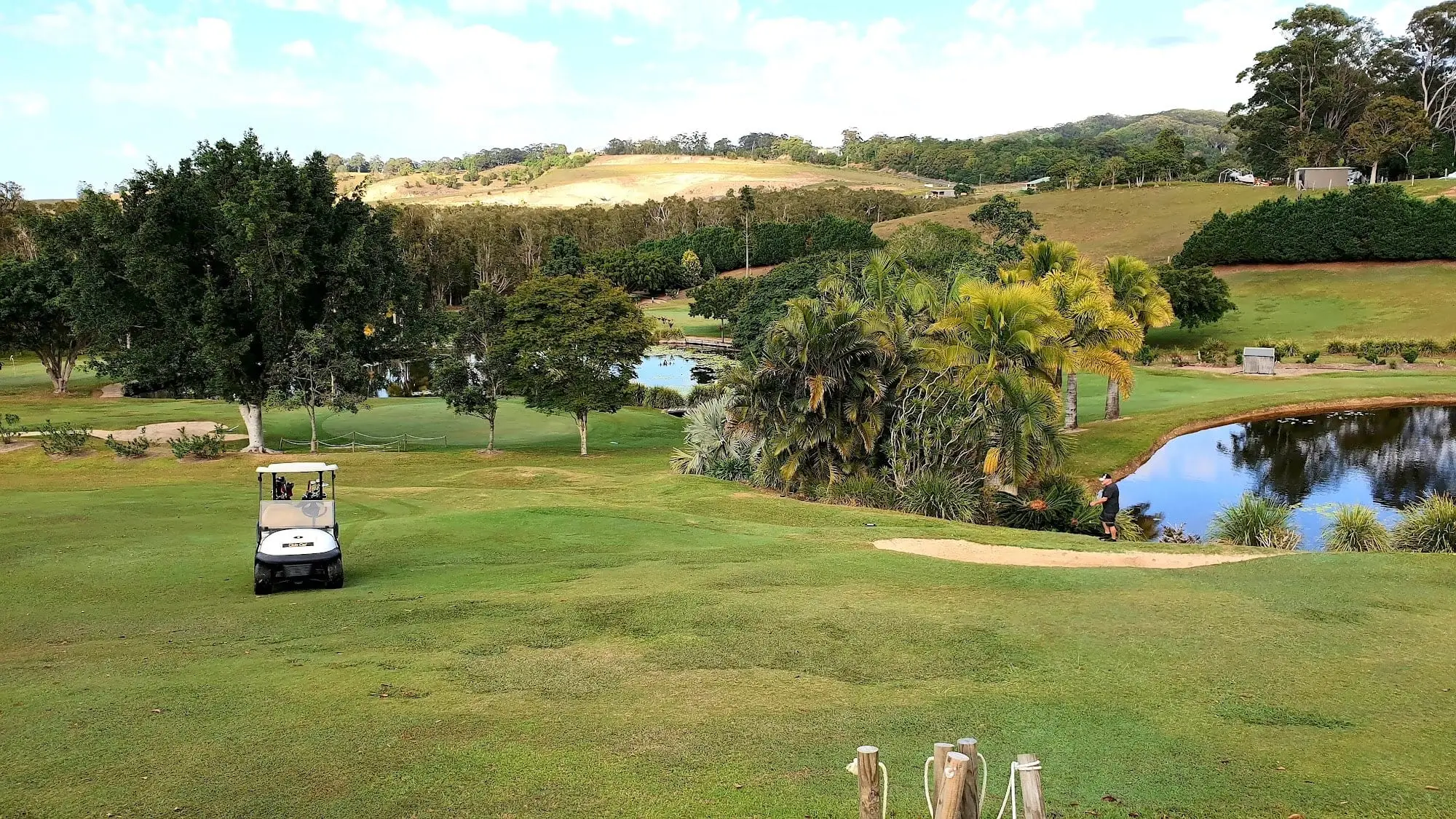 Fairway with pond, bunker and rolling hills beyond